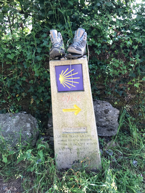 Zapatos de un peregrino sobre símbolo del camino de Santiago de Compostela 